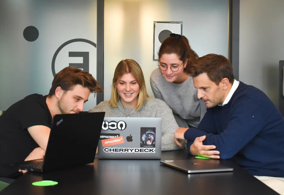 A small team collaborating around a laptop